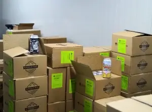Photo de cartons et fûts de craft beer de la brasserie artisanale Basqueland entreposés dans la chambre froide d'Occitanie Boissons.