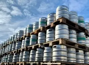 Photo de palettes de fûts de bières pour la distribution de boissons.