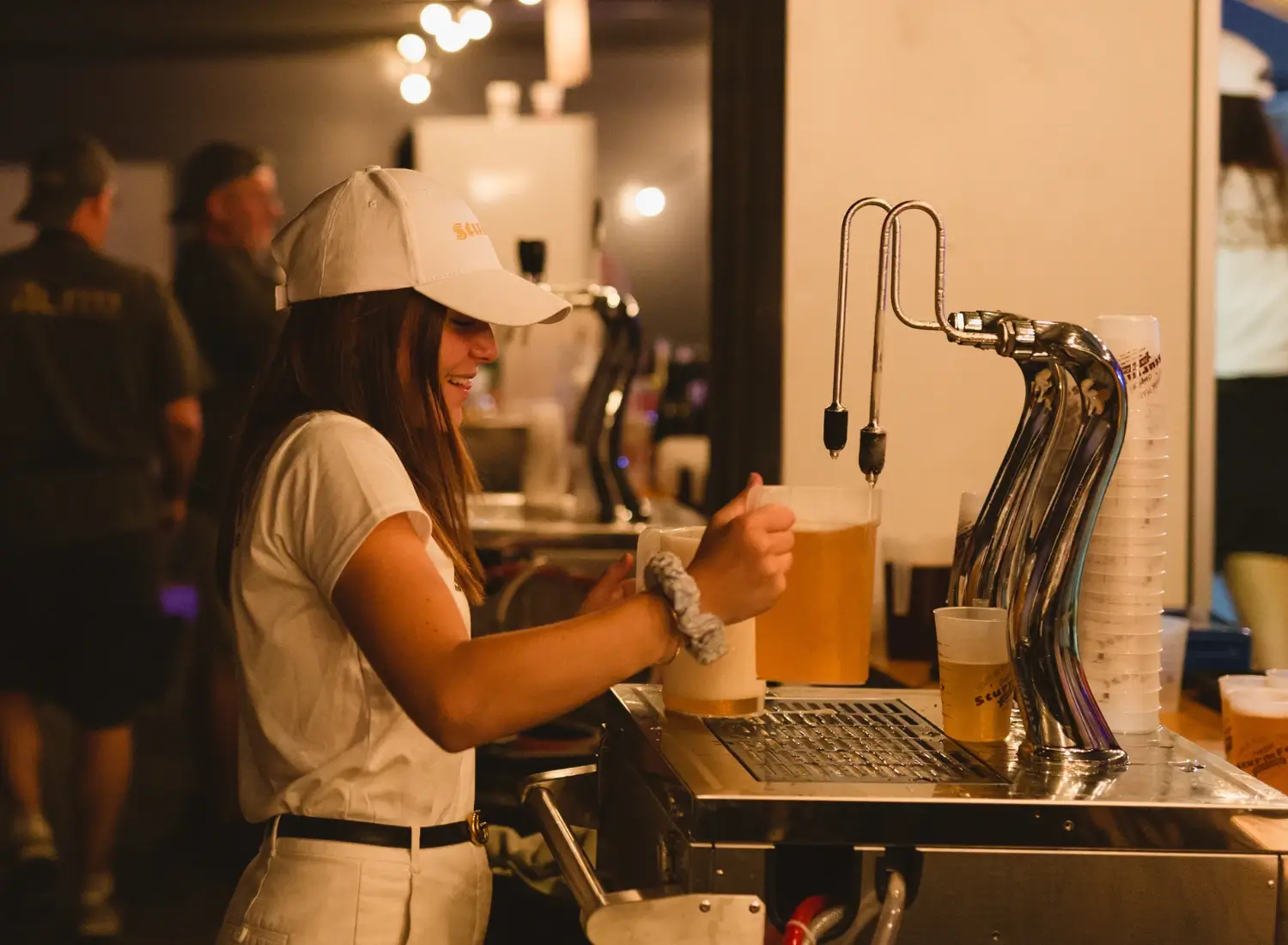 Photo d'une serveuse d'un festival utilisant une machine à bière professionnelle.